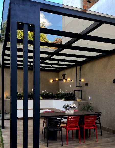 Área gourmet com pergolado e mesa de jantar